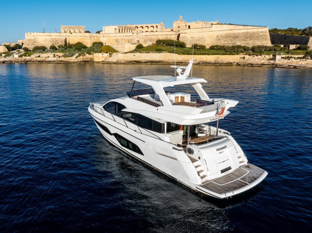 Sunseeker Manhattan 66 floating on the sea near a cliffside